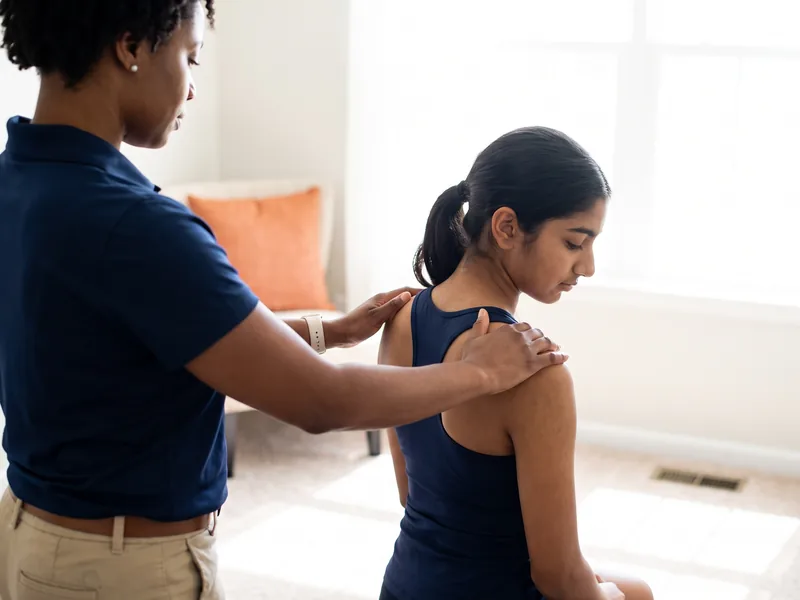 Physical therapist assessing a patient's shoulder movement and mobility