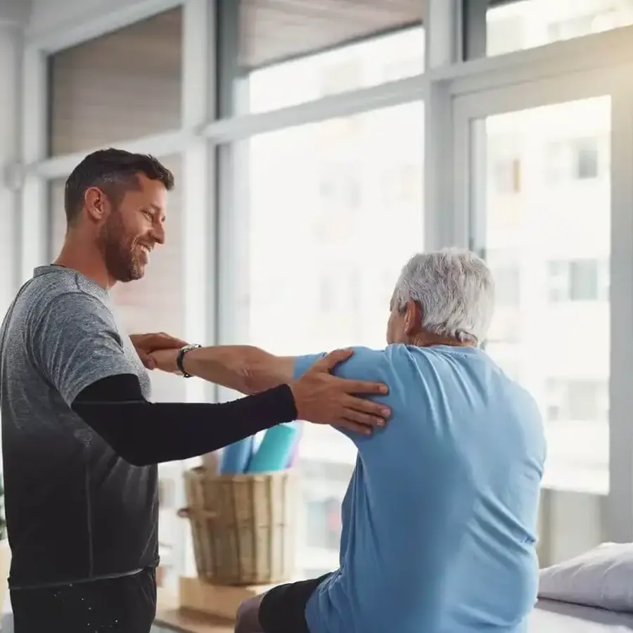 Physical therapist mobilizing a patient's shoulder during a one-on-one session
